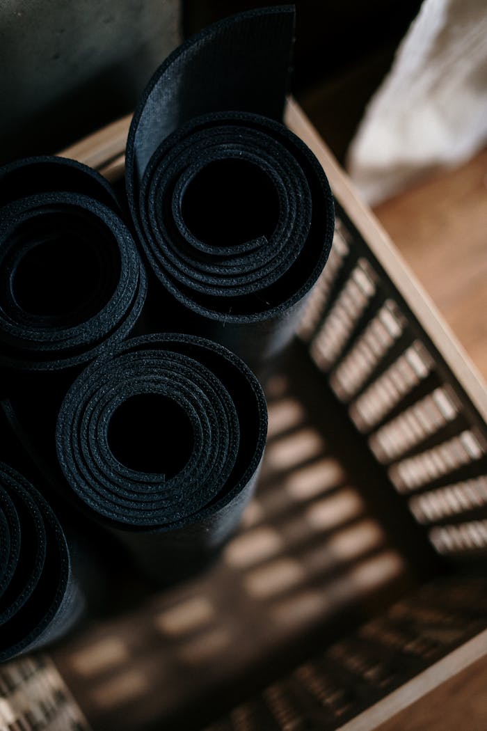 Close-up of rolled yoga mats in a basket at a fitness studio, ideal for yoga or pilates.